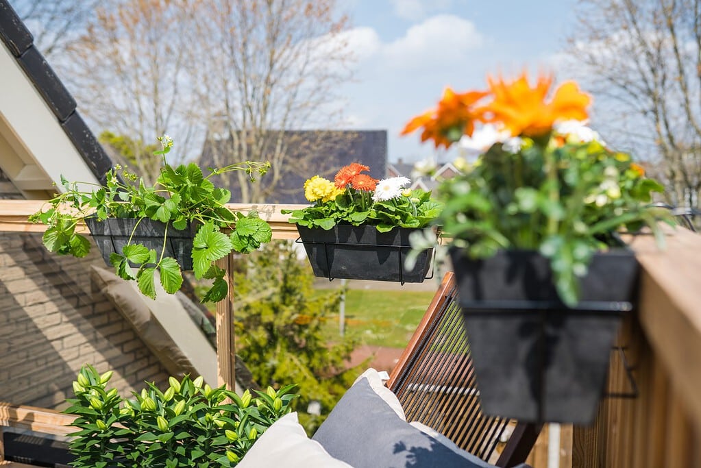Plantenbakken met bloemen die je als balkonbak aan het balkon kunt hangen