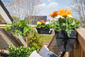 Plantenbakken met bloemen die je als balkonbak aan het balkon kunt hangen