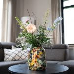 berry blue designed by lammie bloemenvaas met boeket erin op een salontafel in de woonkamer