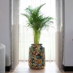 Grote bloempot voor binnen die in de woonkamer staat met een tropische plant erin